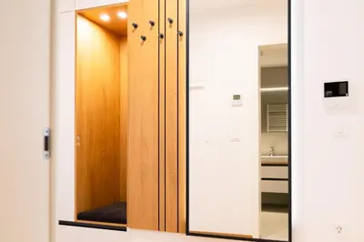 a bathroom with a wooden door and a mirror at Masarykova Residence - Modern 1-Bedroom in City Center & Free Parking in Ljubljana