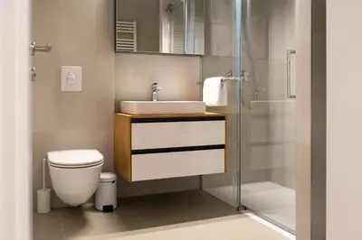 a bathroom with a sink and a toilet and a shower at Masarykova Residence - Modern 1-Bedroom in City Center & Free Parking in Ljubljana