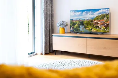 a living room with a tv on a dresser at Masarykova Residence - Modern 1-Bedroom in City Center & Free Parking in Ljubljana