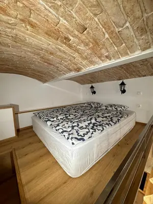 a bed in a room with a brick ceiling at Zenroom Apartments in Ljubljana