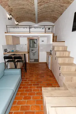 a living room with a couch and stairs and a table at Zenroom Apartments in Ljubljana