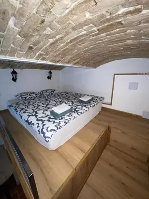 a bed in a room with a wooden floor at Zenroom Apartments in Ljubljana