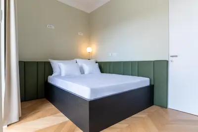 a bed in a room with a green wall at Villa Elizabeth - Grand Family Apartment in Slovenj Gradec