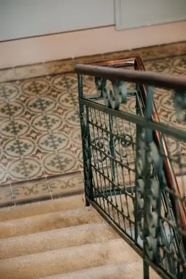 a staircase with a wrought iron railing and a carpet at Villa Elizabeth - Grand Family Apartment in Slovenj Gradec