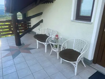 a table and chairs sitting on a porch at Vineyard Cottage Rigelj in Dolenjske Toplice