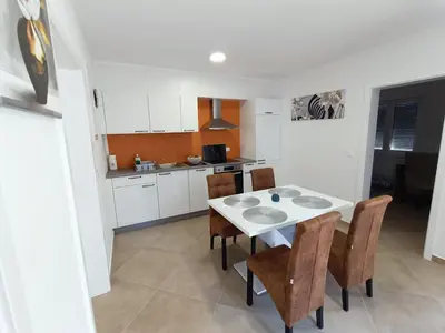 a kitchen with a white table and some chairs at Apartma LANA in Koper