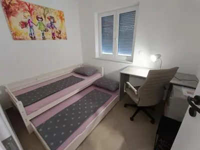a bedroom with two bunk beds and a desk and a chair at Apartma LANA in Koper