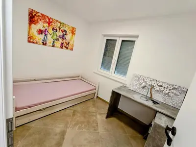 a room with a pink bed and a table at Apartma LANA in Koper