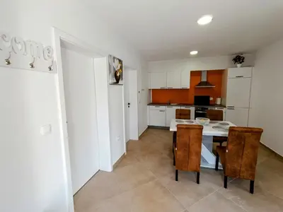 a kitchen with a table and chairs in a room at Apartma LANA in Koper