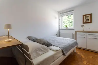 a bedroom with a bed and a desk and a window at Apartments Leonid in Podčetrtek