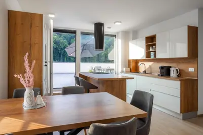 a kitchen with a wooden table and a dining room at Apartment Dalgona Delux in Podčetrtek