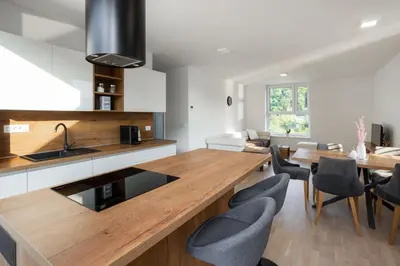 a kitchen with a wooden counter top and a dining room at Apartment Dalgona Delux in Podčetrtek