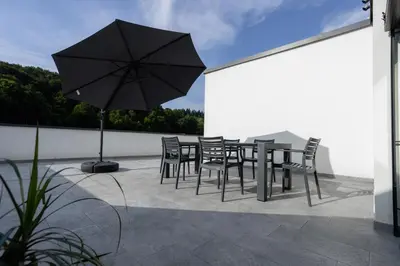 a table and chairs and an umbrella on a patio at Apartment Dalgona Delux in Podčetrtek