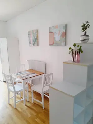 a white dining room with a table and chairs at apartma pika 2 in Nova Gorica