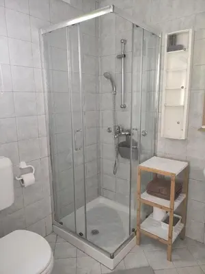 a shower with a glass door in a bathroom at Bungalov in Gozd Martuljek