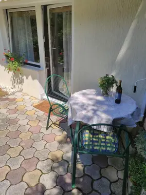 a table and chairs on a patio with a bottle of wine at Bungalov in Gozd Martuljek