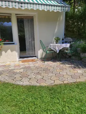 a patio with a table and chairs in front of a house at Bungalov in Gozd Martuljek