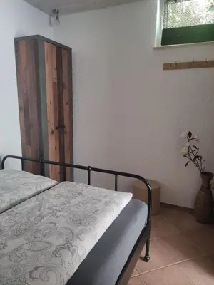 a bedroom with a bed and a window and a door at Bungalov in Gozd Martuljek