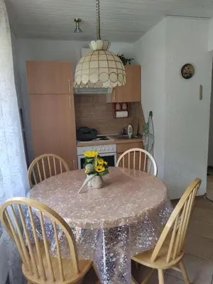 a dining room table with chairs and a vase of flowers at Bungalov in Gozd Martuljek
