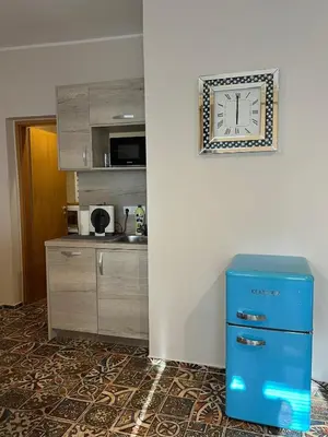 a clock on a wall next to a kitchen at CentralPark Suites in Maribor