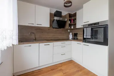 a white kitchen with white cabinets and a sink at Apartma PRI AJHECI in Pristava pri Mestinju