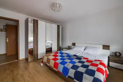a bedroom with a bed with a checkered blanket at Apartma PRI AJHECI in Pristava pri Mestinju