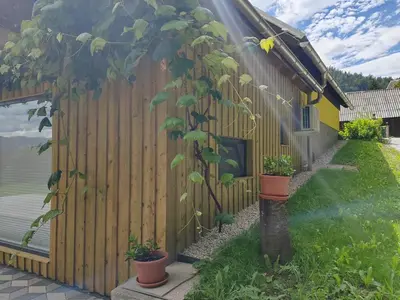 a wooden fence with potted plants next to a house at Honey house in Zgornje Gorje