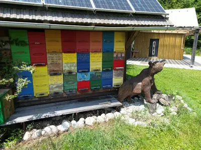 a statue of a bear in front of a building at Honey house in Zgornje Gorje