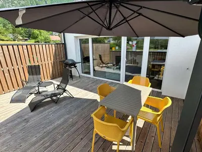 a patio with a table and chairs and an umbrella at Apartment 1 Pearl in Bovec