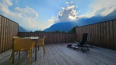 a patio with a table and chairs on a wooden deck at Apartment 1 Pearl in Bovec