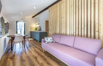 a living room with a purple couch and a kitchen at Apartmaji Robida in Sežana