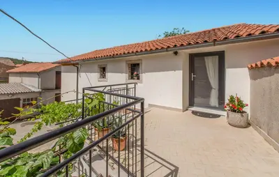 a house with a staircase leading to a balcony at Apartmaji Robida in Sežana
