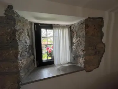 a window in a room with a stone wall at Apartmaji Robida in Sežana