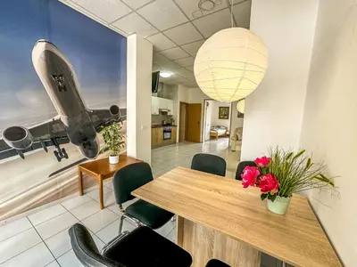a room with a table and chairs and a plane on the wall at Apartmaji Vogelnik in Radovljica