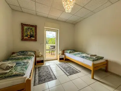 a bedroom with two beds and a window at Apartmaji Vogelnik in Radovljica
