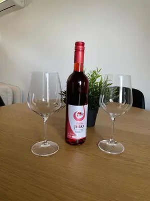 a bottle of wine sitting between two glasses on a table at Maja's Sunrise Haven in Mala Nedelja