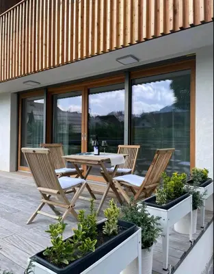 a patio with a table and chairs and some plants at Apartma Gorna in Kranjska Gora