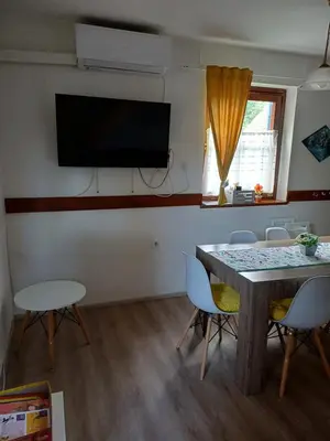 a room with a table and chairs and a flat screen tv at Hišica 6084 Terme Čatež in Mostec