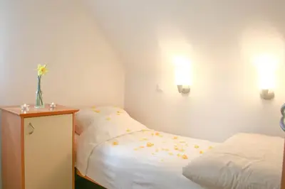 a bedroom with two beds and a dresser with flowers at VILA BREDA in Bled center in Bled