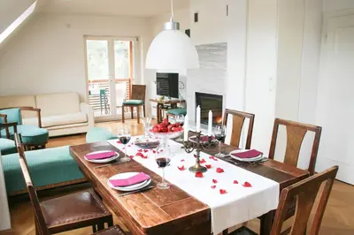 a dining room with a table with red roses on it at VILA BREDA in Bled center in Bled