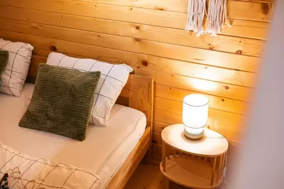 a small room with a bed with a candle on a table at Apartma Farm Bliss in Zgornja Velka