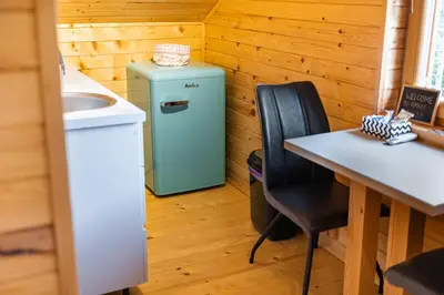 a small refrigerator in a room with a table at Apartma Farm Bliss in Zgornja Velka