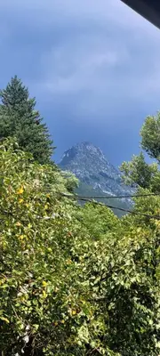 a mountain in the distance with trees in the foreground at Apartma Brin in Bovec