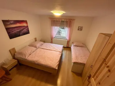 a small bedroom with two beds and a window at Apartma Brin in Bovec