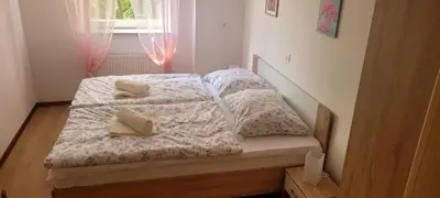 a bedroom with two beds with white sheets and a window at Apartma Brin in Bovec