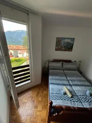 a bedroom with a bed and a large window at Apartma Tine in Bovec