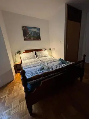 a large bed in a bedroom with a wooden floor at Apartma Tine in Bovec