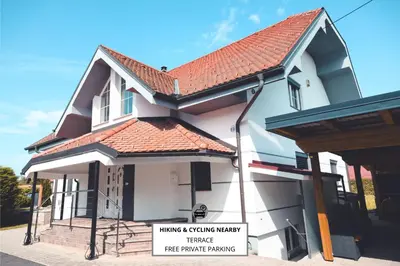 a house with a sign in front of it at Apartments & rooms Ksenya in Spodnja Hajdina