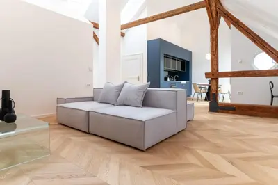 a living room with a couch and a wooden floor at Villa Elizabeth - Mansard Apartment for 4 in Slovenj Gradec