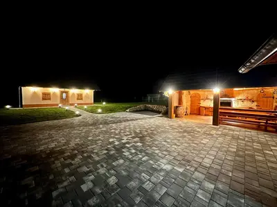 a brick patio in front of a building at night at FAMILY HOUSE Pri Kovaču in Soča